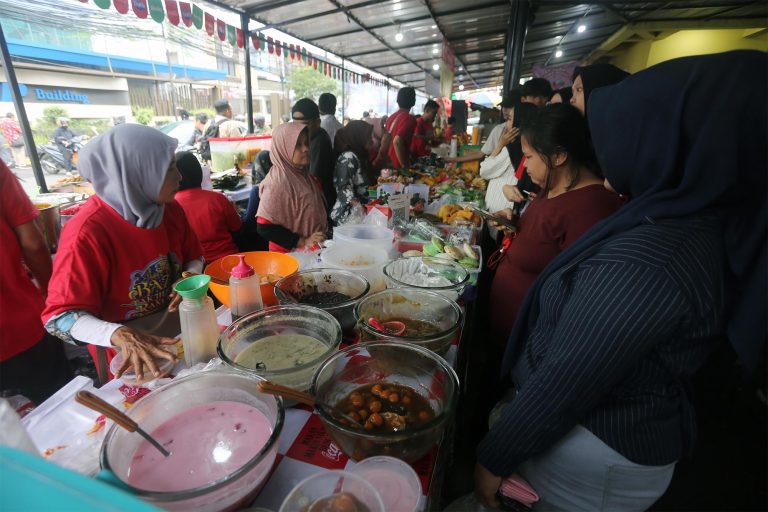 Pedagang melayani pembeli di Pasar Takjil Ramadan Bendungan Hilir (Benhil), Jakarta, Kamis (19/2/2026).  Pasar Takjil Benhil kembali menjadi magnet bagi warga Jakarta selama bulan suci Ramadan. Berlokasi di kawasan Pasar Takjil Bendungan Hilir, sentra kuliner musiman ini dipadati masyarakat yang berburu aneka hidangan untuk berbuka puasa.  Beragam jajanan ringan tersedia dengan harga terjangkau. Gorengan dijual sekitar Rp4.000 per biji, bubur sumsum dibanderol Rp15.000–Rp20.000 per porsi, sementara ayam goreng dijual Rp15.000–Rp20.000 per potong. Aroma makanan yang menggugah selera berpadu dengan keramaian pengunjung, menciptakan suasana khas Ramadan yang selalu dinantikan setiap tahunnya.***(Foto: Ekobisnis.com/Farras Dawi)